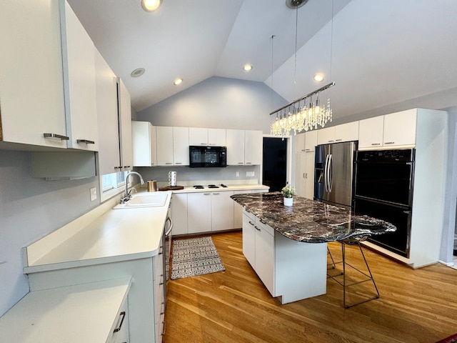 kitchen featuring a sink, black appliances, a kitchen island, and white cabinets