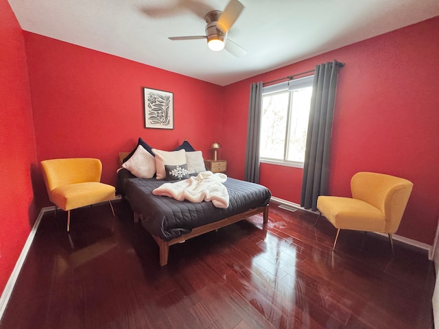 bedroom with ceiling fan, baseboards, and wood finished floors