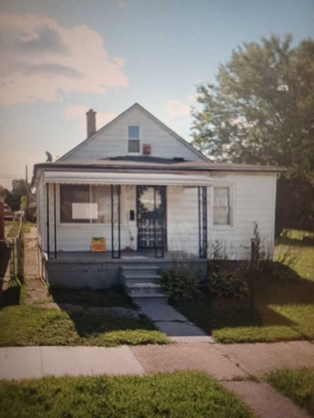 view of front of home featuring covered porch and a lawn