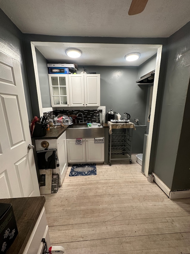 laundry area with ceiling fan, sink, a textured ceiling, and light hardwood / wood-style flooring