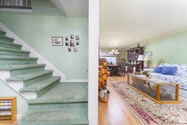 staircase with hardwood / wood-style flooring and a chandelier