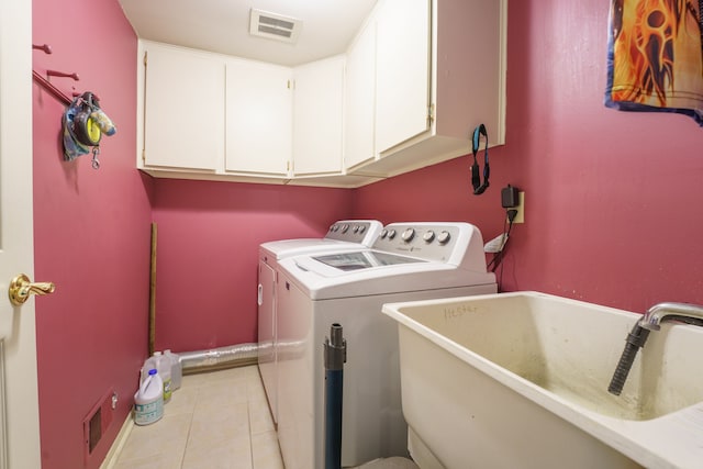 laundry area featuring light tile patterned flooring, cabinets, sink, and washer and dryer