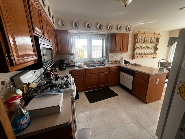 kitchen with a peninsula, a sink, dishwasher, stainless steel microwave, and wallpapered walls