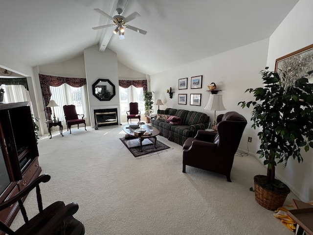 living room with beam ceiling, a glass covered fireplace, carpet flooring, ceiling fan, and high vaulted ceiling