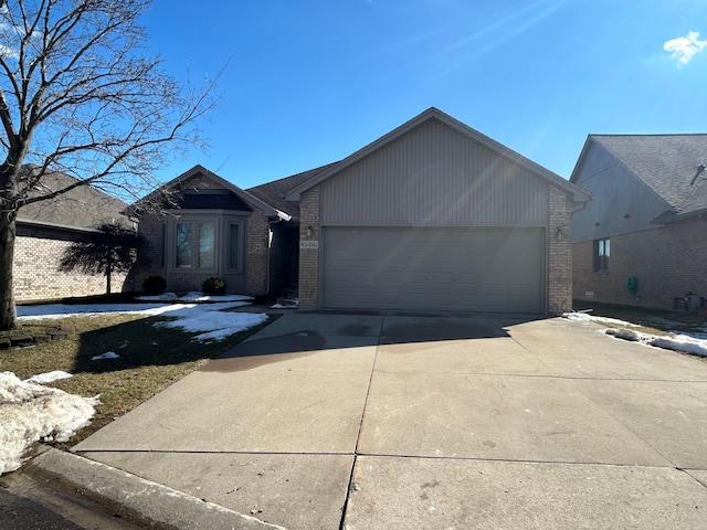 single story home with brick siding, driveway, and an attached garage