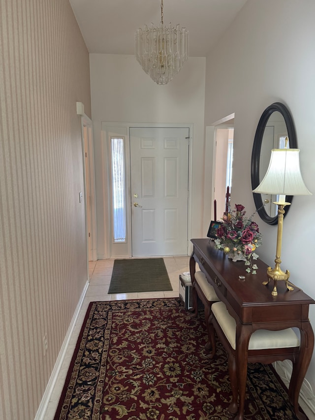 entryway with light tile patterned floors, baseboards, and an inviting chandelier