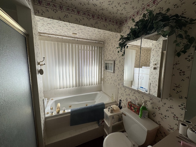 full bathroom featuring a whirlpool tub, toilet, and wallpapered walls