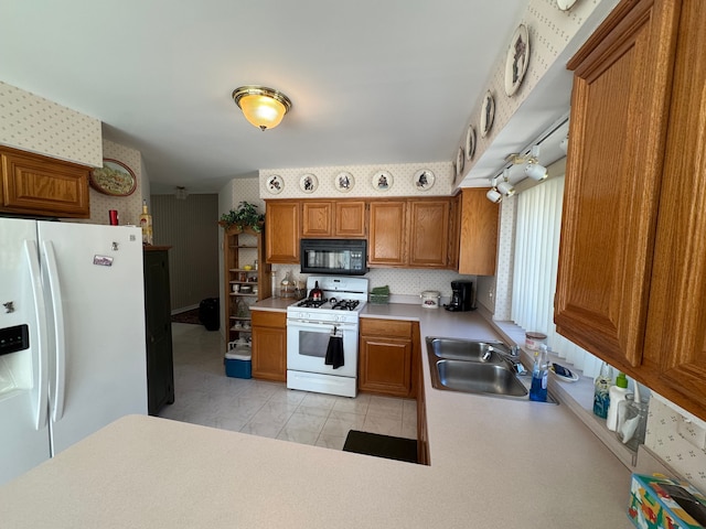 kitchen with white appliances, a sink, light countertops, brown cabinets, and wallpapered walls