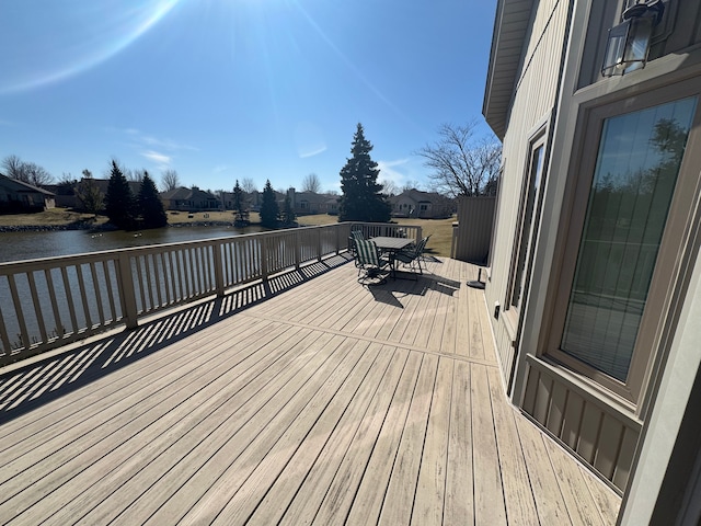 wooden deck featuring outdoor dining space and a water view