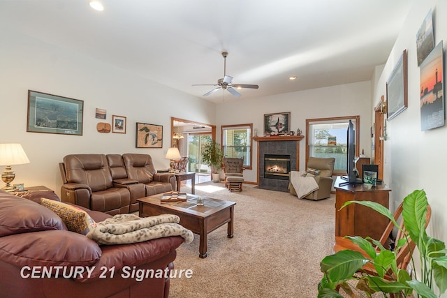 carpeted living room with a tile fireplace and ceiling fan