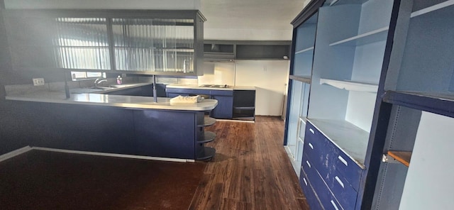 kitchen with dark wood-type flooring, blue cabinetry, black gas stovetop, and kitchen peninsula