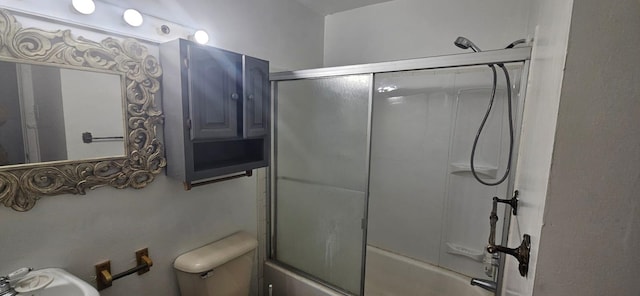 full bathroom featuring sink, toilet, and bath / shower combo with glass door