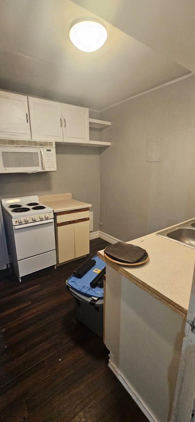 kitchen with white appliances, white cabinets, and dark hardwood / wood-style floors