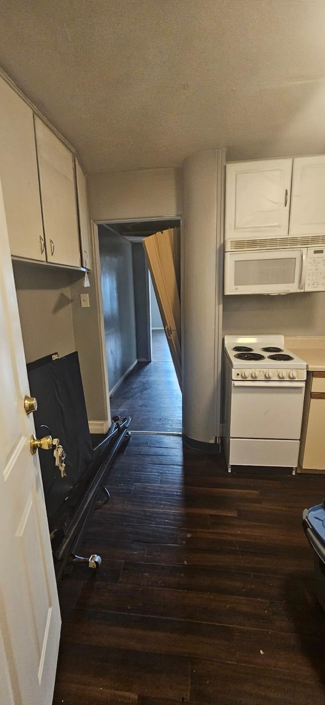 kitchen featuring white appliances, dark hardwood / wood-style flooring, white cabinetry, and a textured ceiling