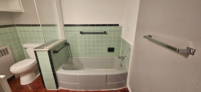 bathroom featuring toilet, radiator, tile walls, and a tub