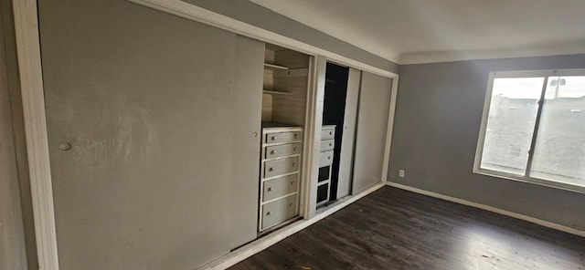 unfurnished bedroom with a closet and dark hardwood / wood-style flooring