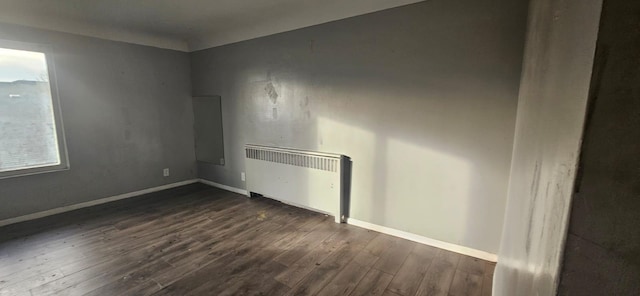 empty room with radiator and dark wood-type flooring