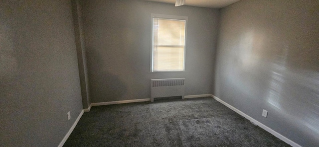 carpeted spare room featuring radiator heating unit