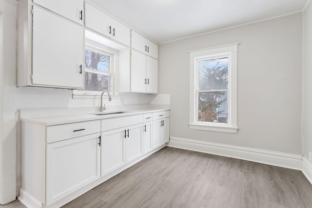 kitchen with sink, a healthy amount of sunlight, and white cabinets