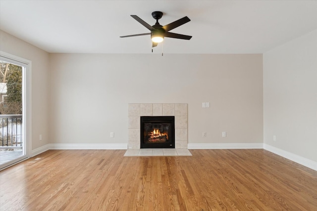 unfurnished living room with a tile fireplace, light hardwood / wood-style flooring, and ceiling fan