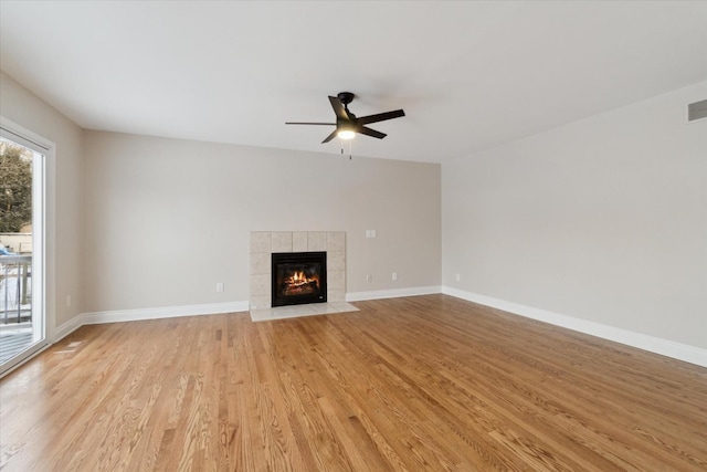 unfurnished living room with a fireplace, light wood-type flooring, and ceiling fan