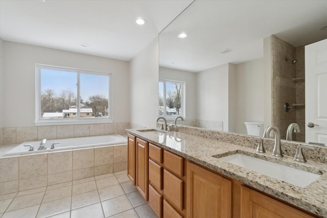 bathroom with vanity, toilet, a relaxing tiled tub, and tile patterned flooring