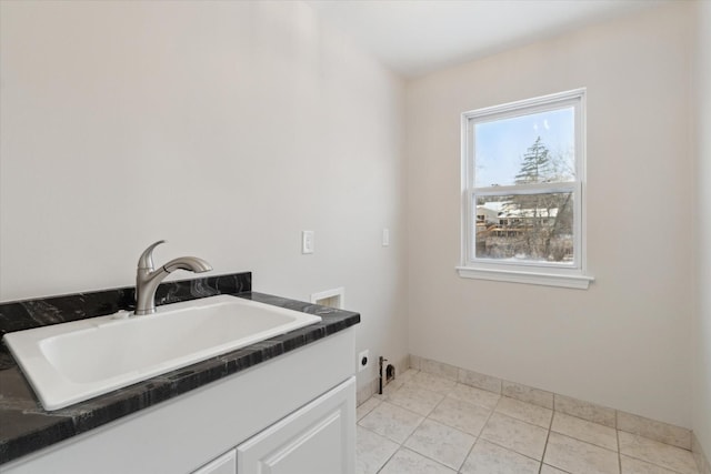 washroom with washer hookup, sink, electric dryer hookup, cabinets, and light tile patterned flooring