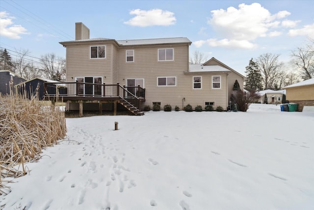 snow covered house with a deck