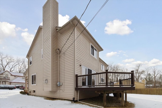 snow covered property with a wooden deck