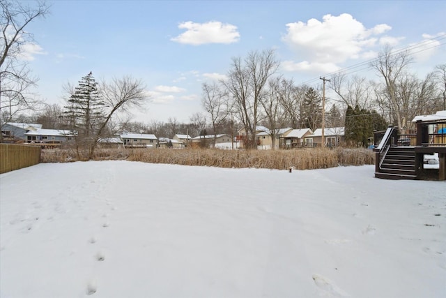 snowy yard featuring a wooden deck