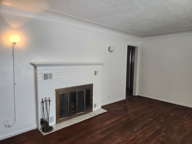 unfurnished living room with dark wood-type flooring, a textured ceiling, and a fireplace