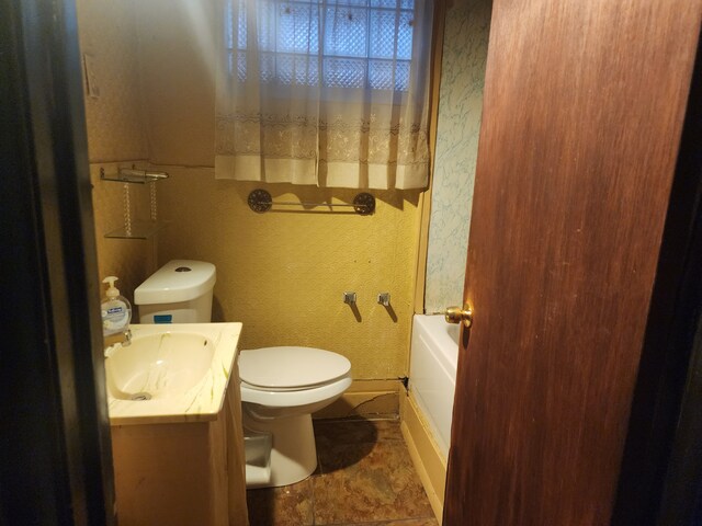 bathroom featuring toilet, vanity, and a bathtub