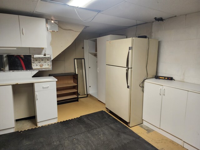 kitchen featuring white refrigerator and white cabinetry