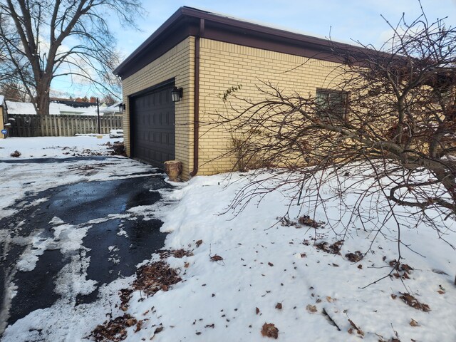 snow covered property with a garage