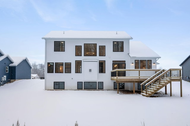 snow covered property with a wooden deck