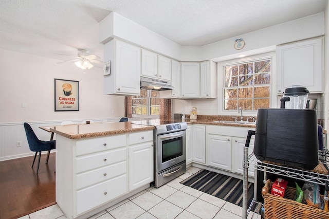 kitchen featuring sink, stainless steel electric range, white cabinets, and light tile patterned floors