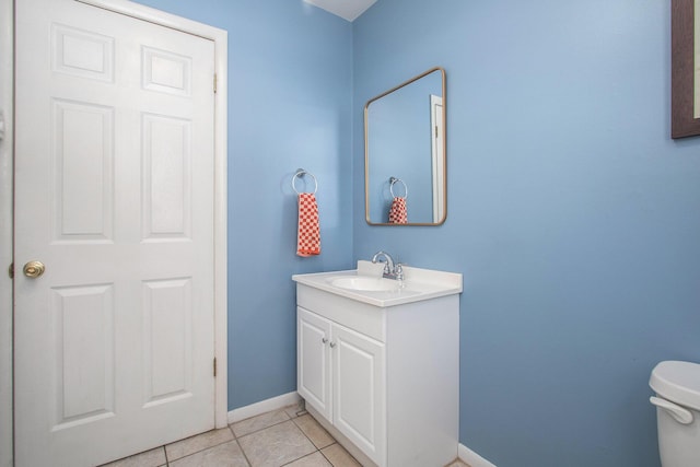 bathroom with toilet, vanity, and tile patterned floors