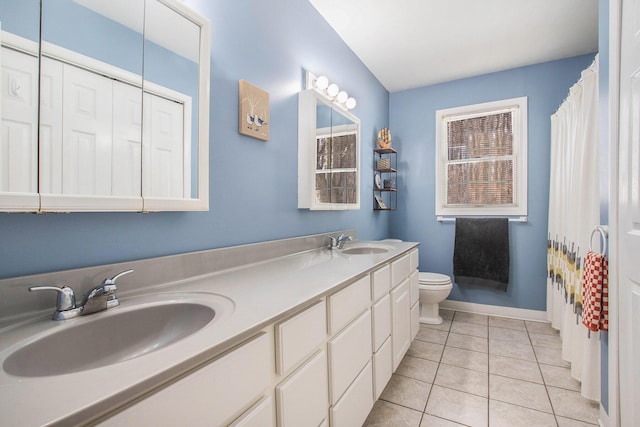 bathroom featuring curtained shower, tile patterned flooring, vanity, and toilet