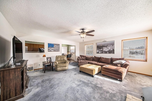 living room with a textured ceiling, carpet floors, and ceiling fan