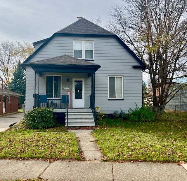 bungalow-style home with a front yard and covered porch