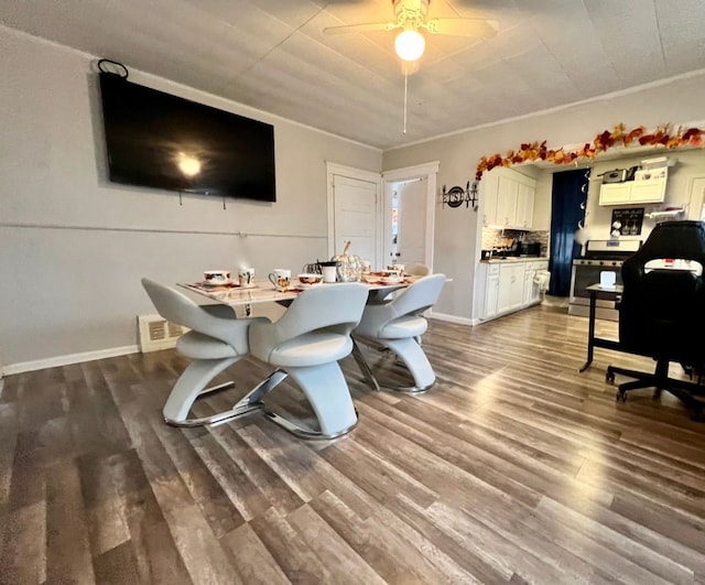 dining area featuring ceiling fan, crown molding, and dark hardwood / wood-style flooring