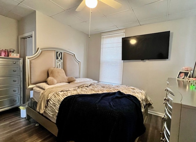 bedroom with ceiling fan, a paneled ceiling, and dark hardwood / wood-style floors