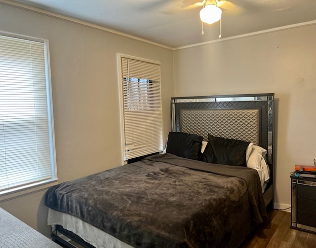 bedroom with ceiling fan, crown molding, and dark wood-type flooring