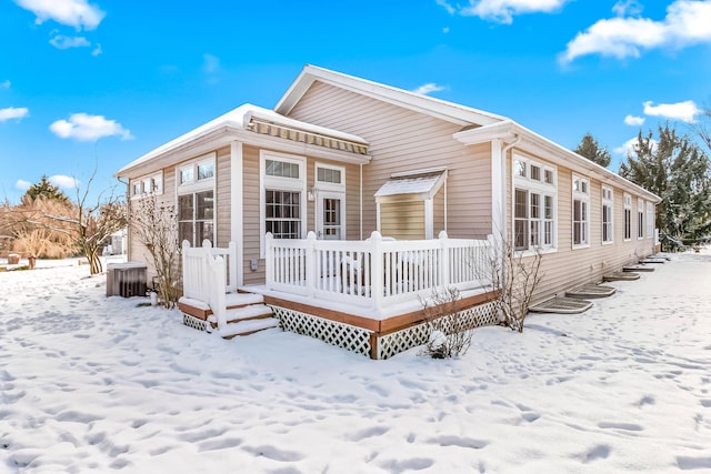 snow covered property with a wooden deck