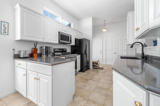 kitchen featuring appliances with stainless steel finishes, hanging light fixtures, white cabinets, light tile patterned flooring, and sink