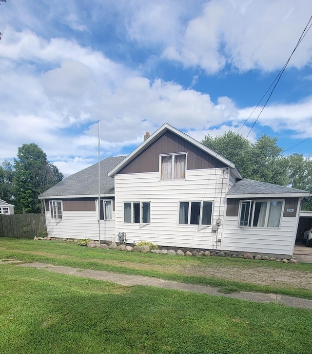 rear view of house featuring a lawn