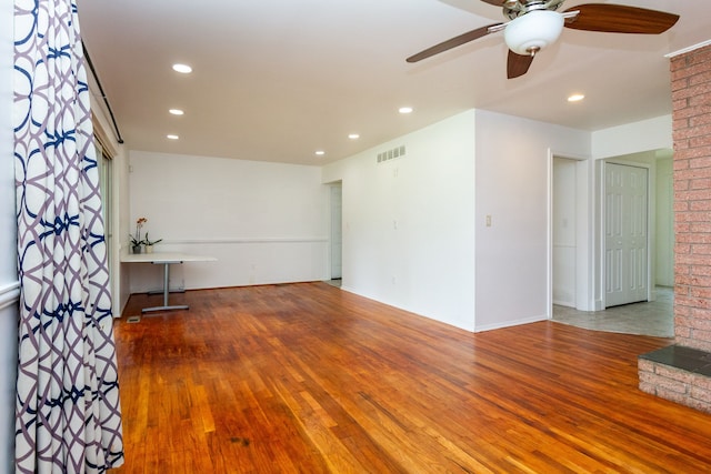 unfurnished living room with ceiling fan and hardwood / wood-style flooring