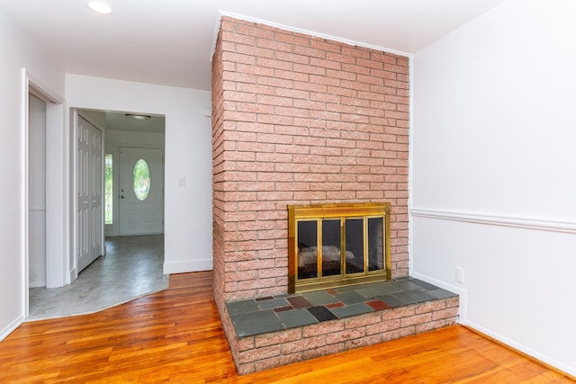 21918 Knudsen Dr, Grosse Ile, MI 48138 - unfurnished living room with wood finished floors, a brick fireplace, and baseboards