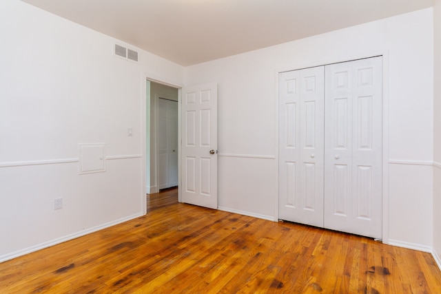 unfurnished bedroom with a closet and hardwood / wood-style floors