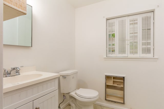 bathroom with tile patterned flooring, vanity, and toilet